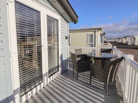 A deck with a table and chairs at CG 55