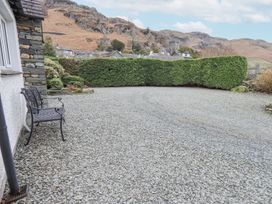 An outdoor space with gravel, a bench, and a hedge at Thrang View in Chapel Stile