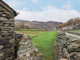 A field with a stone wall and buildings nearby at Thrang View in Chapel Stile