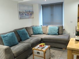 A living room with a sofa, table, and decorative items at Rockfish Cottage in Brixham