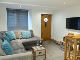 A living room with a sofa and table at Rockfish Cottage in Brixham