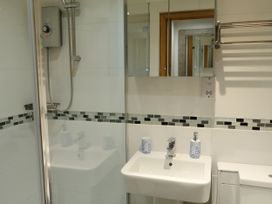 A bathroom with a shower, sink and toilet at Rockfish Cottage in Brixham