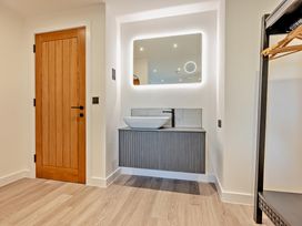 A bathroom with a sink and mirror at Arvor Suite 1.0 in Marhamchurch
