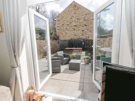 A garden patio with furniture and planters at Ramblers Cottage in Alnwick