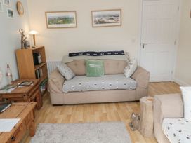 A living room with a couch and bookshelf at Ramblers Cottage in Alnwick