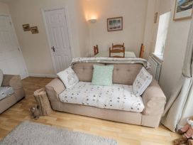 A living room with a sofa and dining table at Ramblers Cottage in Alnwick