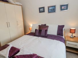 A bedroom with a bed and wardrobe at Ramblers Cottage in Alnwick