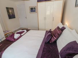 A bedroom with a bed and cabinet at Ramblers Cottage in Alnwick
