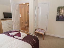 A bedroom with a bed and a bathroom in Ramblers Cottage Alnwick