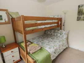 A bedroom with a bunk bed and double bed at Ramblers Cottage in Alnwick