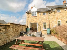 A garden with outdoor seating and table at Ramblers Cottage in Alnwick