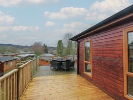 An outdoor deck with a table and chairs at High Lake View Lodge White Cross Bay near Troutbeck Bridge