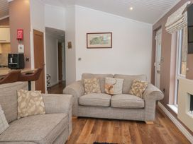 A living room with sofas and a television at High Lake View Lodge White Cross Bay near Troutbeck Bridge