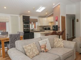 A kitchen with a dining area and sofa at High Lake View Lodge White Cross Bay near Troutbeck Bridge