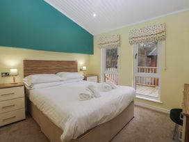 A bedroom with a double bed and windows at High Lake View Lodge White Cross Bay near Troutbeck Bridge