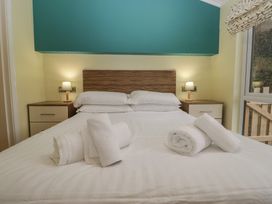 A bedroom with a bed and nightstands at High Lake View Lodge White Cross Bay near Troutbeck Bridge