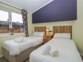 A bedroom with two beds and a nightstand at High Lake View Lodge White Cross Bay near Troutbeck Bridge