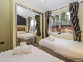 A bedroom with two beds and a window at High Lake View Lodge White Cross Bay near Troutbeck Bridge