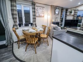 A dining area with a table and chairs at Lakeside Lodge in Stonham Aspal