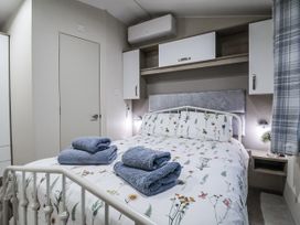 A bedroom with a bed and towels on top at Lakeside Lodge in Stonham Aspal