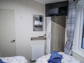 A bedroom with a mirror and television at Lakeside Lodge in Stonham Aspal