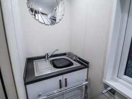 A laundry room with a sink and mirror at Lakeside Lodge in Stonham Aspal