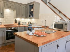 A kitchen with cabinets, a sink, and kitchen appliances at Ostlers Burford