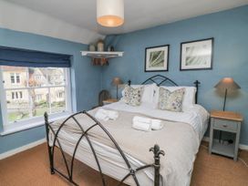 A bedroom with a bed and nightstand at Ostlers in Burford