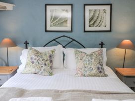 A bedroom with a bed and wall art at Ostlers in Burford