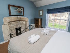 A bedroom with a bed and a fireplace at Ostlers in Burford