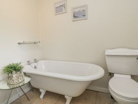A bathroom with a bathtub and toilet at Ostlers in Burford