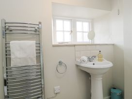 A bathroom with a sink and towel warmer at Ostlers Burford