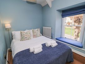 A bedroom with a bed and window seat at Ostlers Burford