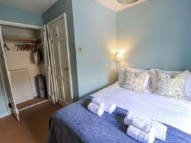 A bedroom with a bed and wardrobe at Ostlers Burford
