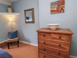 A bedroom with a dresser and chair at Ostlers in Burford