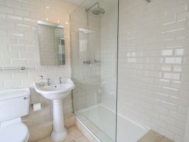 A bathroom with a shower, sink, and toilet at Ostlers, Burford