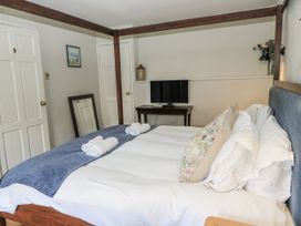 A bedroom with a bed and television at Ostlers Burford