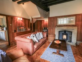A living room with a sofa, coffee table, and fireplace at Ostlers in Burford