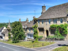 A building with a tree and road at Ostlers in Burford