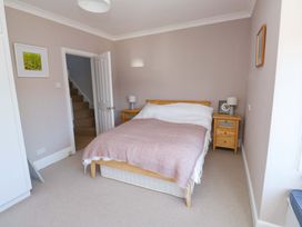 A bedroom with a bed, nightstand, and staircase at 43 Sandquay Road in Dartmouth