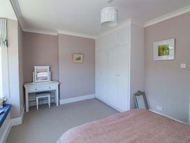 A bedroom with a bed, wardrobe, vanity table, and mirror at 43 Sandquay Road Dartmouth
