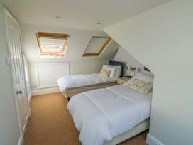 A bedroom with two beds and a wardrobe at 43 Sandquay Road in Dartmouth