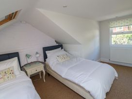 A bedroom with two beds and a window at 43 Sandquay Road Dartmouth