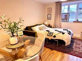 A bedroom with a sofa and bed along with a dining table at Cotswolds Farmhouse Cottage