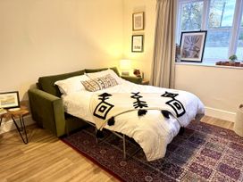 A bedroom featuring a sofa bed and various decor at Cotswolds Farmhouse Cottage