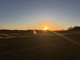 A sunset over fields with a shed at Cotswolds Farmhouse Cottage