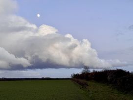 A field with clouds and a moon in the sky at Cotswolds Farmhouse Cottage