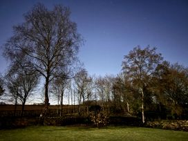A night sky with stars and trees in a garden at Cotswolds Farmhouse Cottage