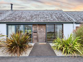 The entrance of Beachcombers Marhamchurch with plants and a pathway