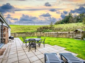 A garden with table and chairs at Beachcombers in Marhamchurch